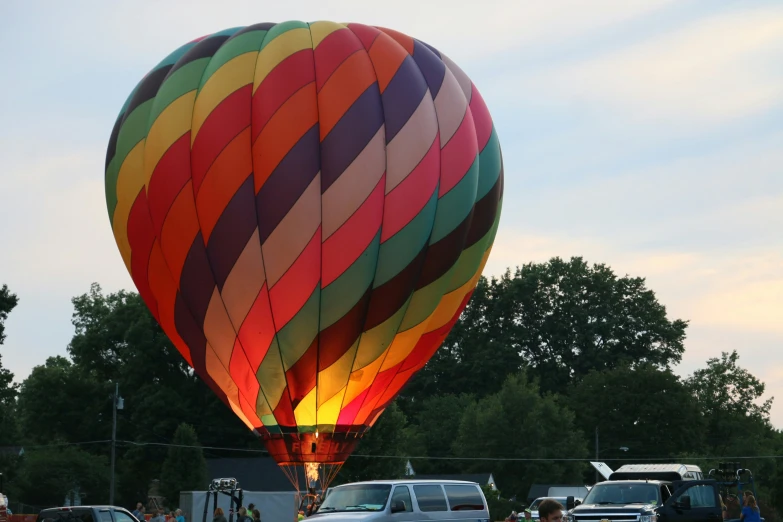 the large multicolored  air balloon is being flown