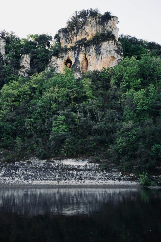 some mountains with a body of water on one side and trees growing on the other