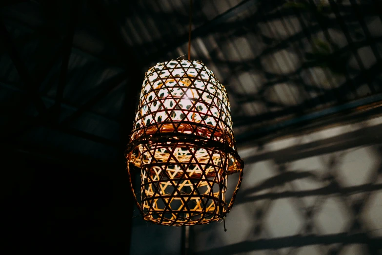 a brown and white lamp hanging from a metal structure