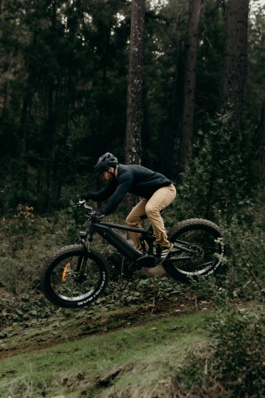 the man is riding his bike in the forest