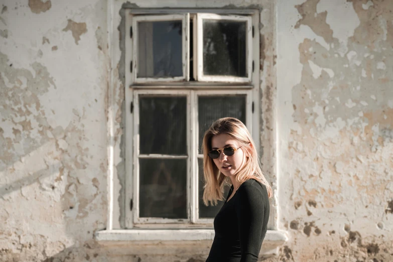 a woman is posing for a po in front of an old building