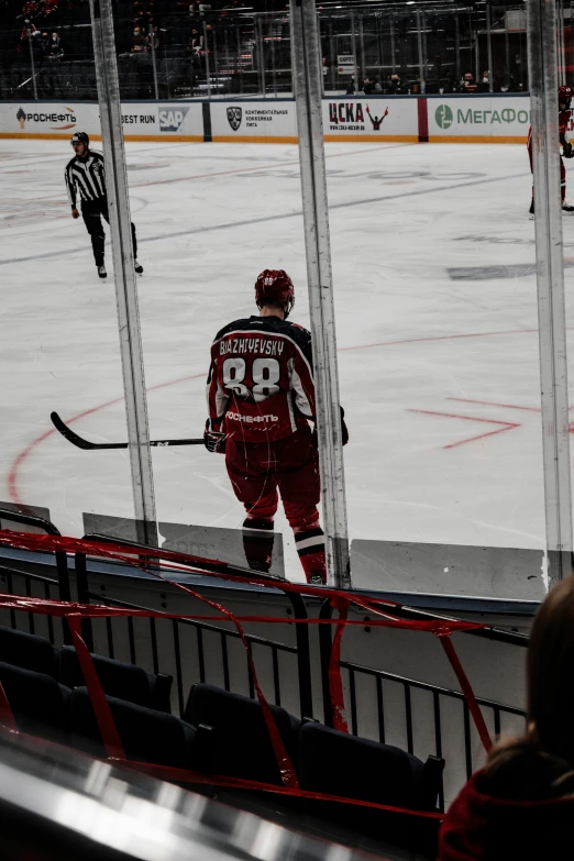 hockey players standing around looking out the window at soing