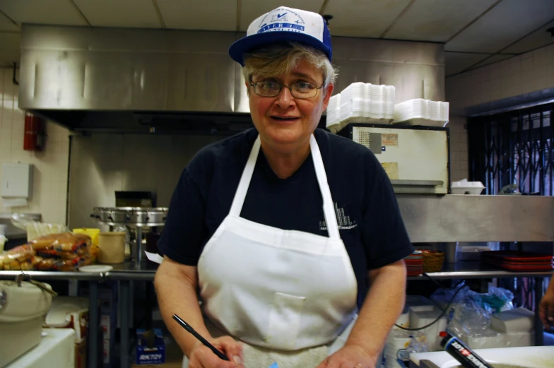 a woman that is wearing an apron and holding a knife