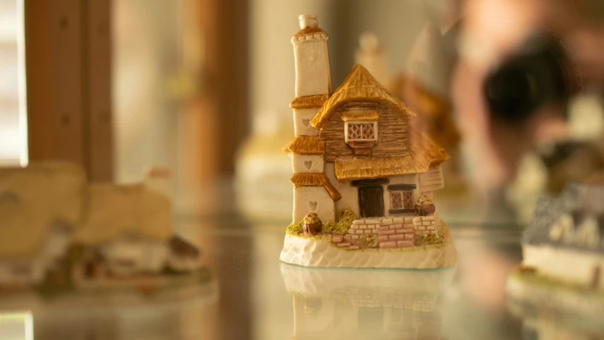 a close up image of a small house figurine on a glass table