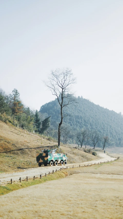 a truck driving down a dirt road with trees in the distance
