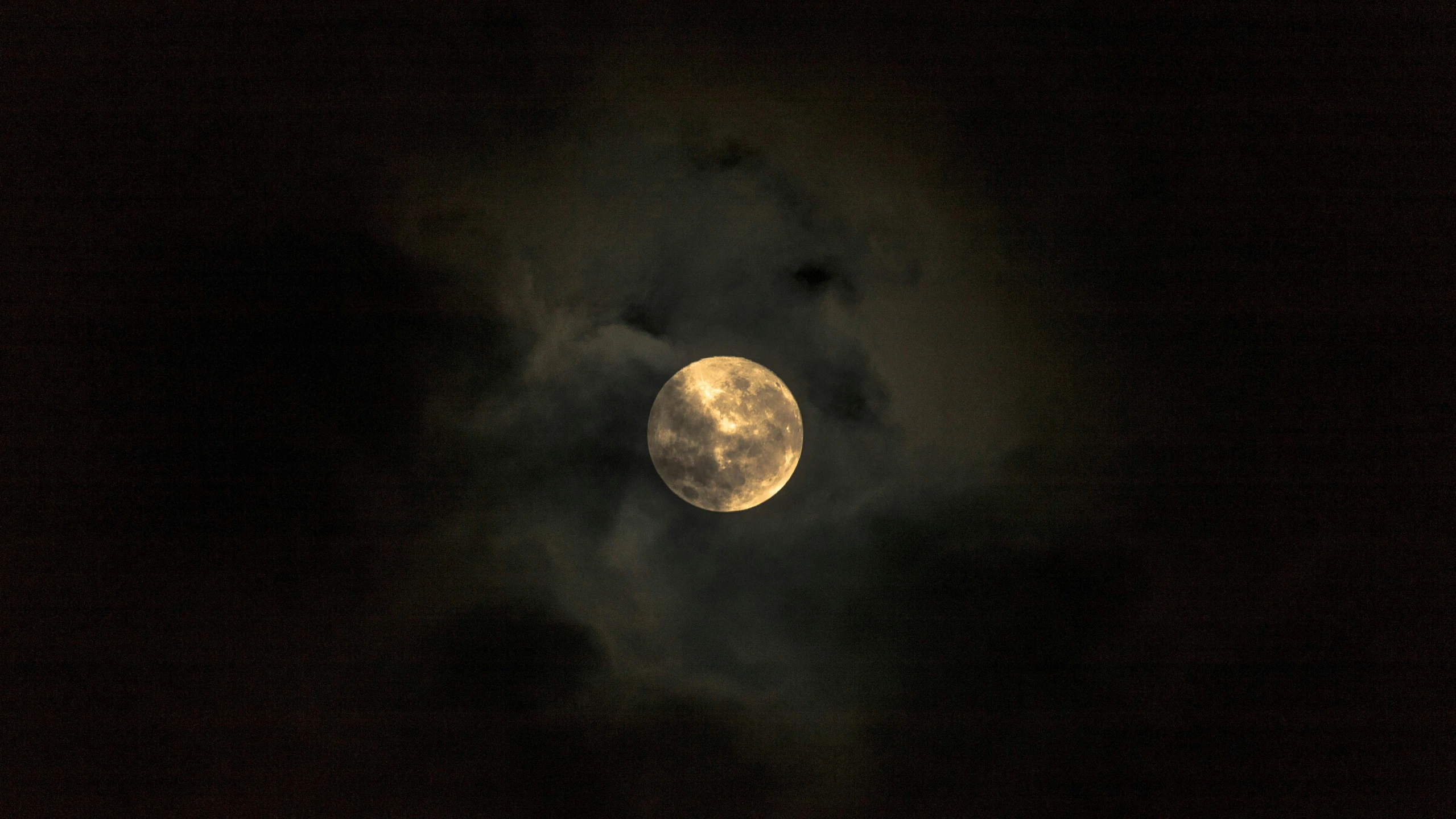 a cloudy night sky filled with a full moon