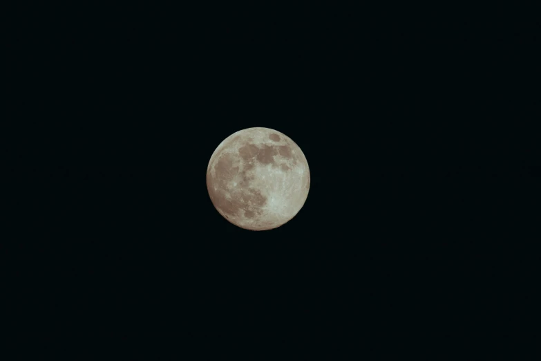 a full moon rises over a city in the dark night sky