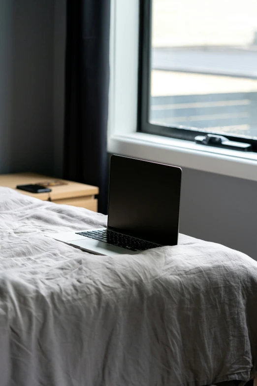 a laptop computer sitting on top of a bed