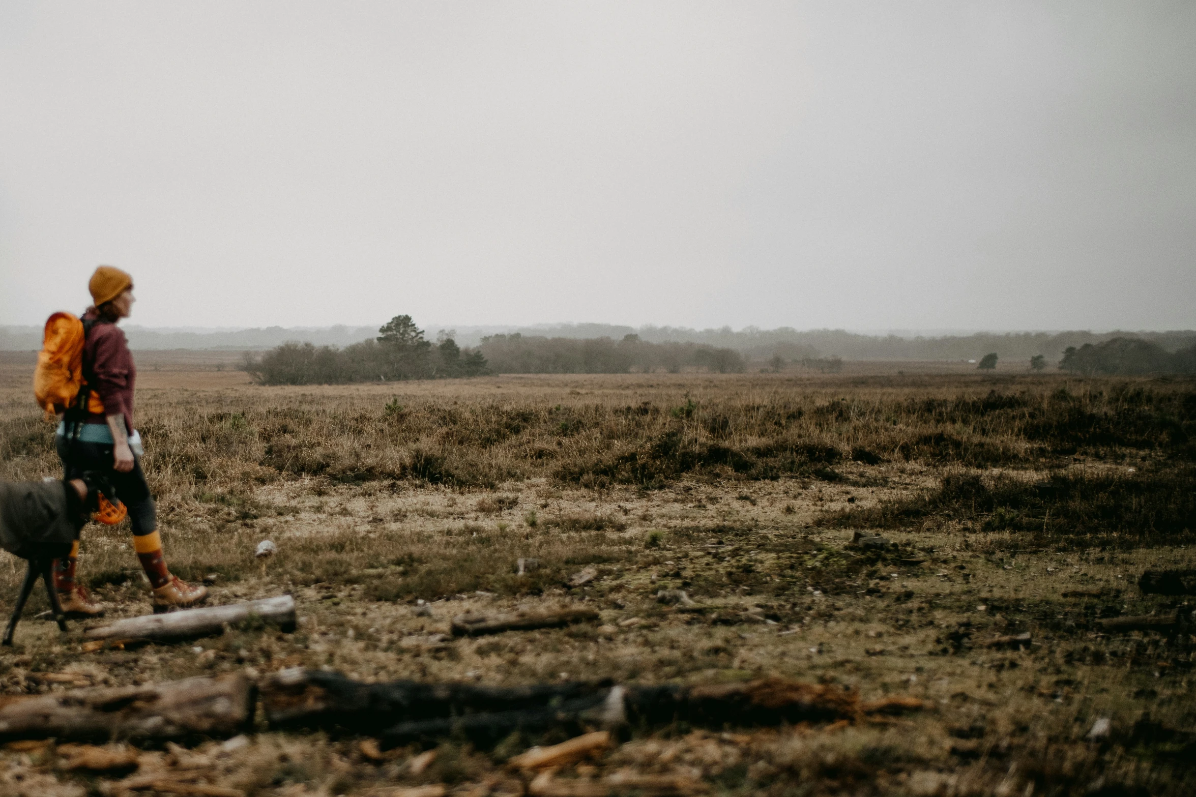 a young woman holding onto a bag in the middle of a field