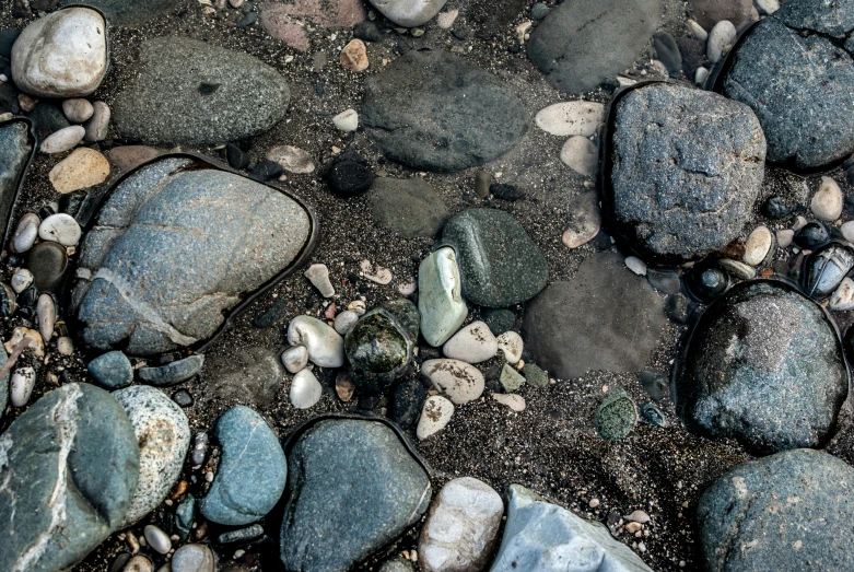 rocks covered with sand and pebbles in water