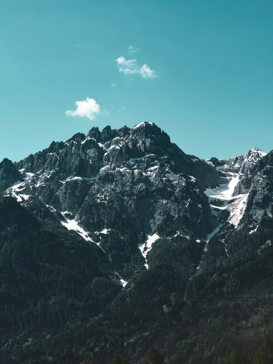 a snow covered mountain with a few patches of white on the top