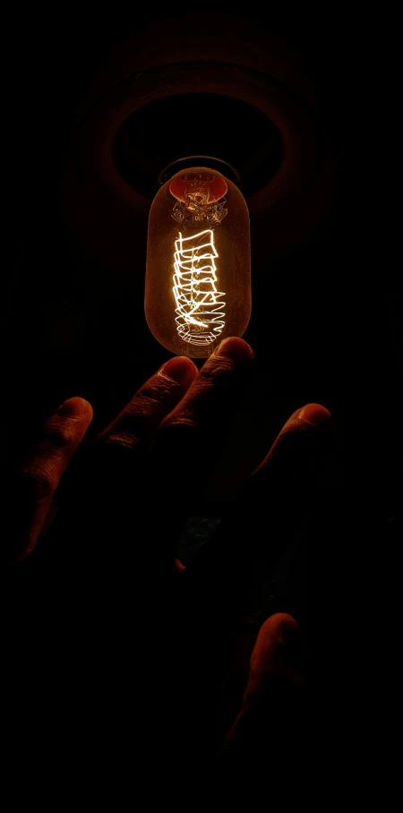 a glowing mason jar is being held in the dark