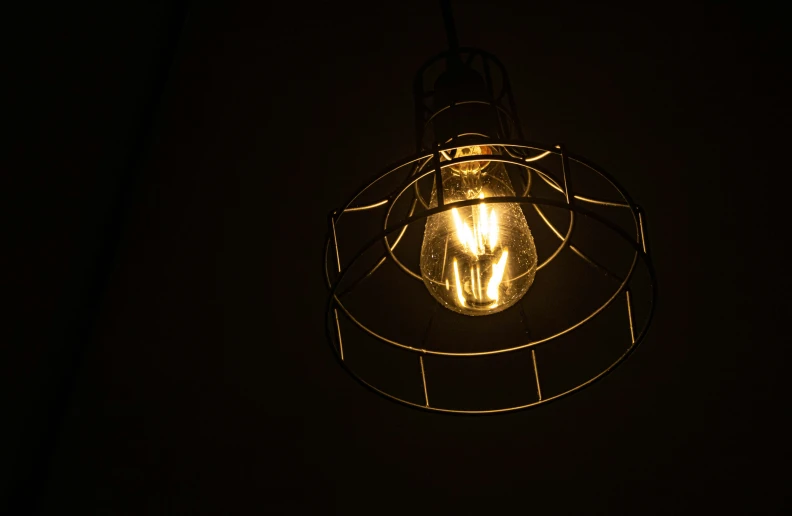 a lamp with an object attached to it is in the dark