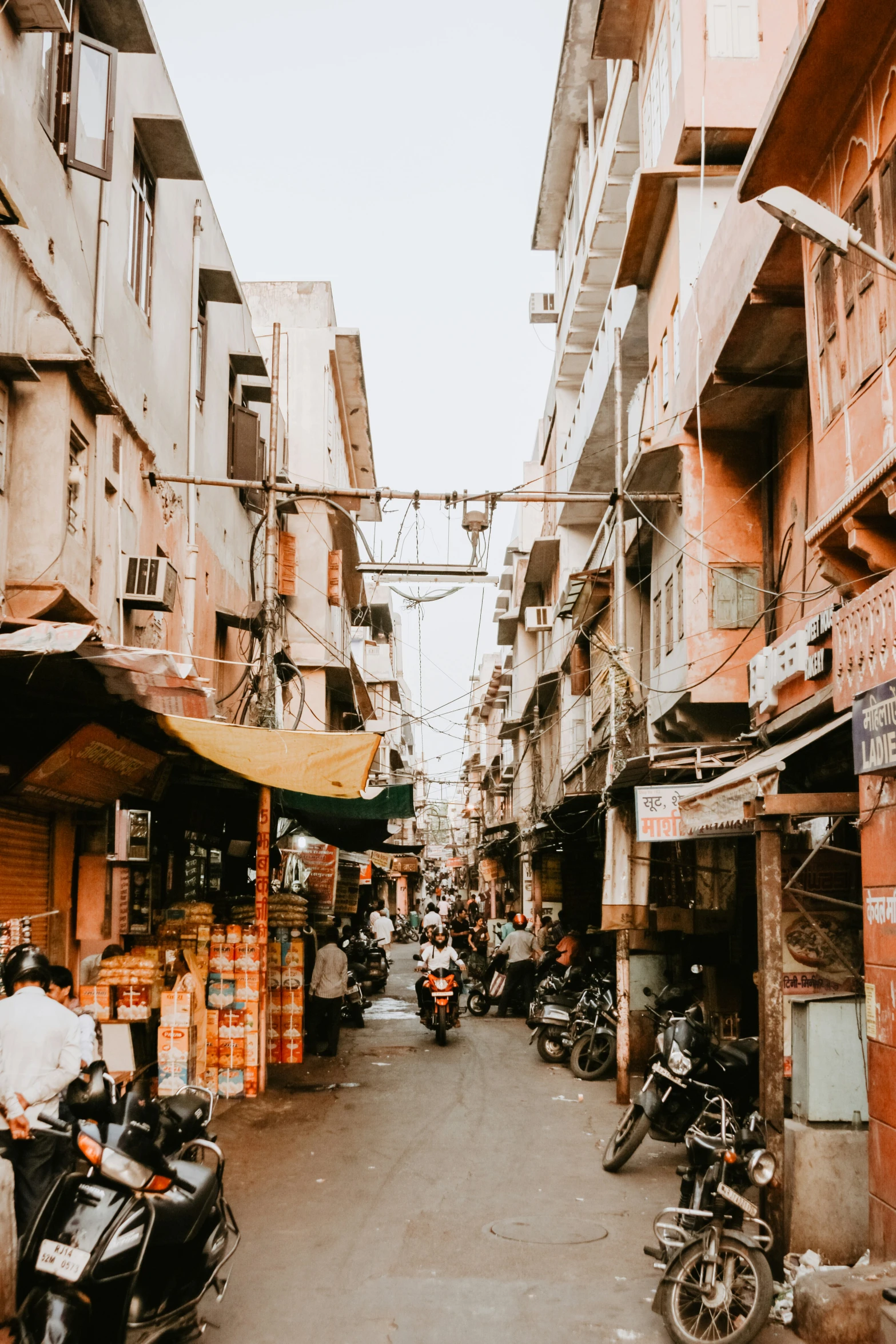 a street view with scooters, motorcycles and buildings