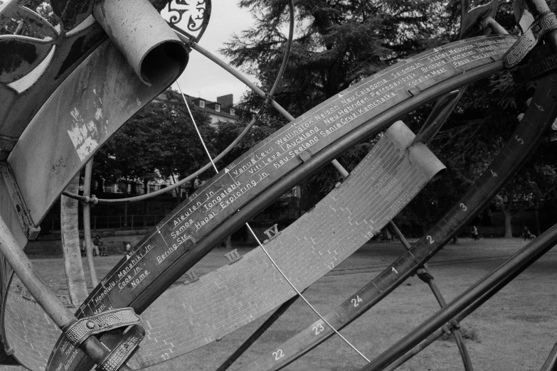 a metal sculpture in the middle of a park with words written on it