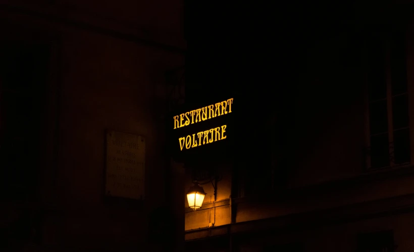 the sign is glowing at night in the dark
