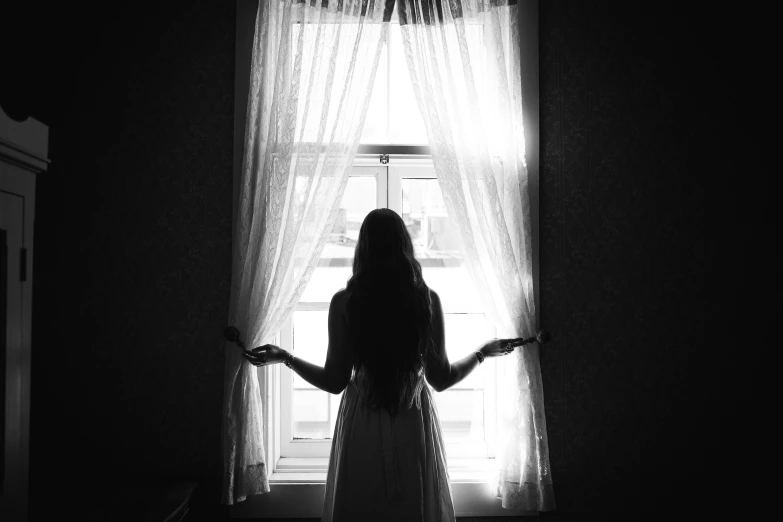 a woman is standing in front of a window