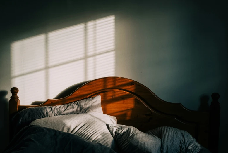 a bedroom with the bed turned down in the sunlight