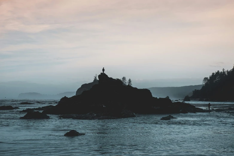 a lighthouse on a rocky island by the ocean