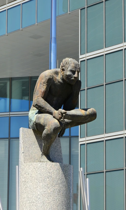 statue of a person carrying a board in front of a building