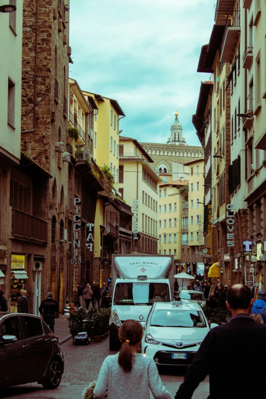 a person holding the hand of a child walking down a city street