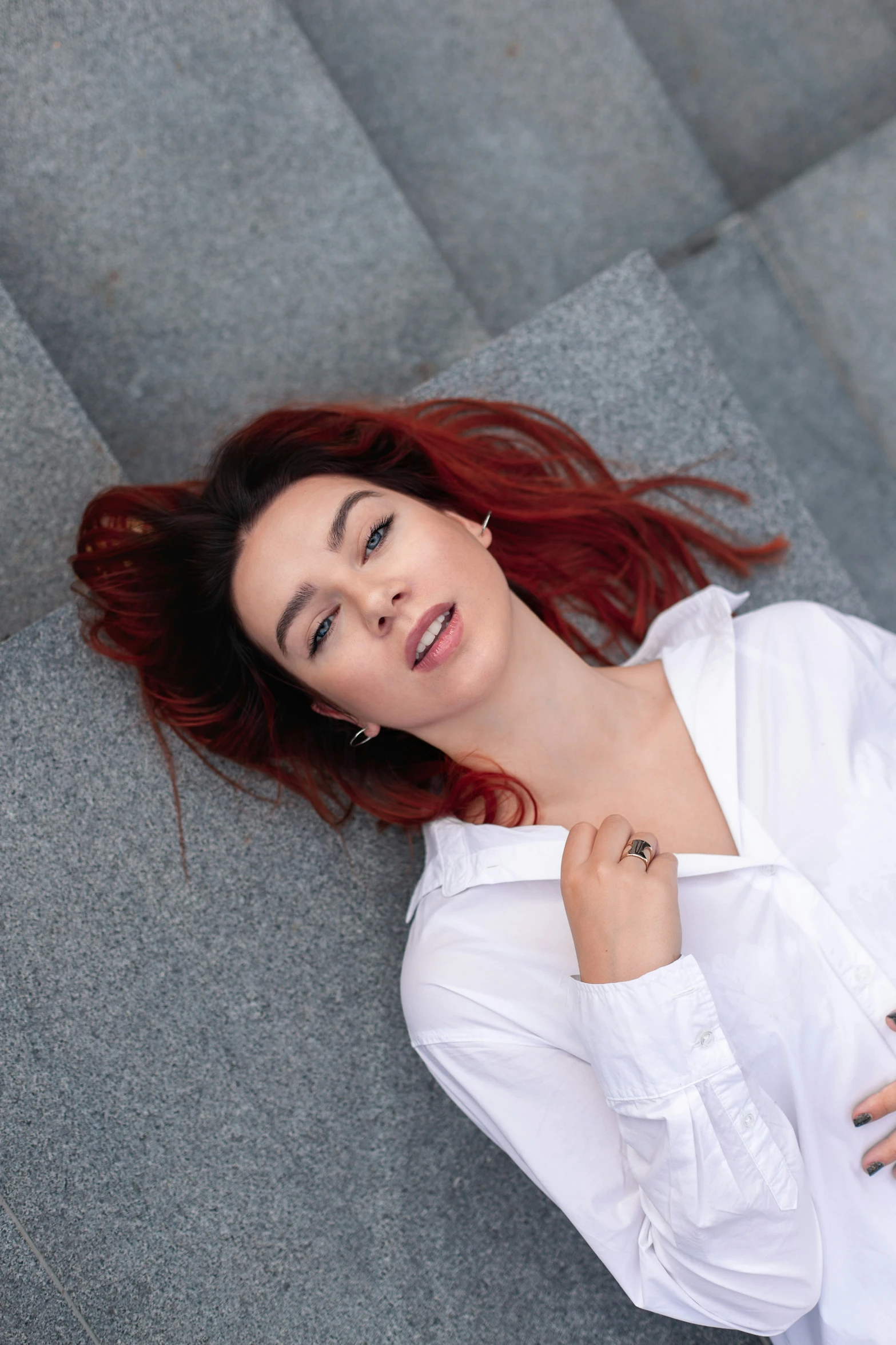 a beautiful young woman laying on a grey couch