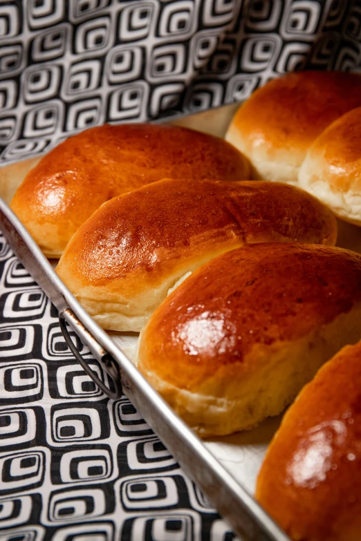 several baked buns are lined up on a sheet