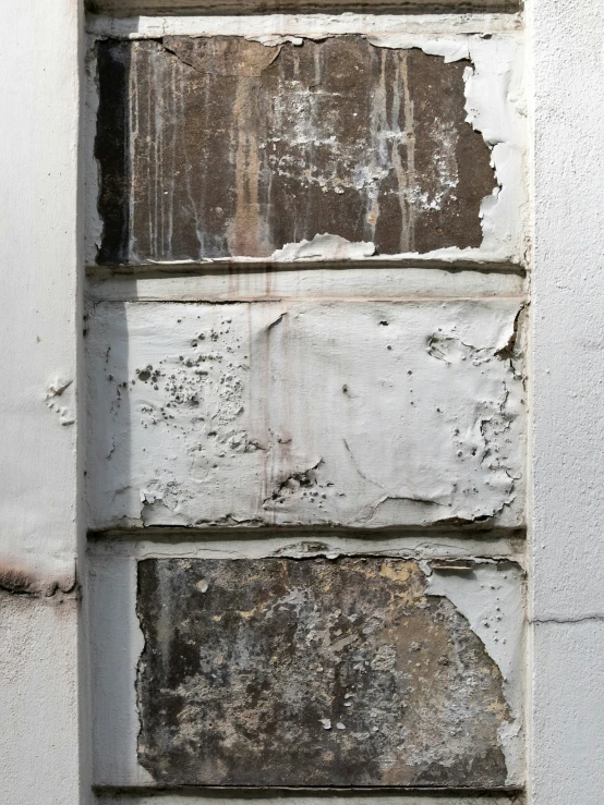 a white wall with some peeling paint on it
