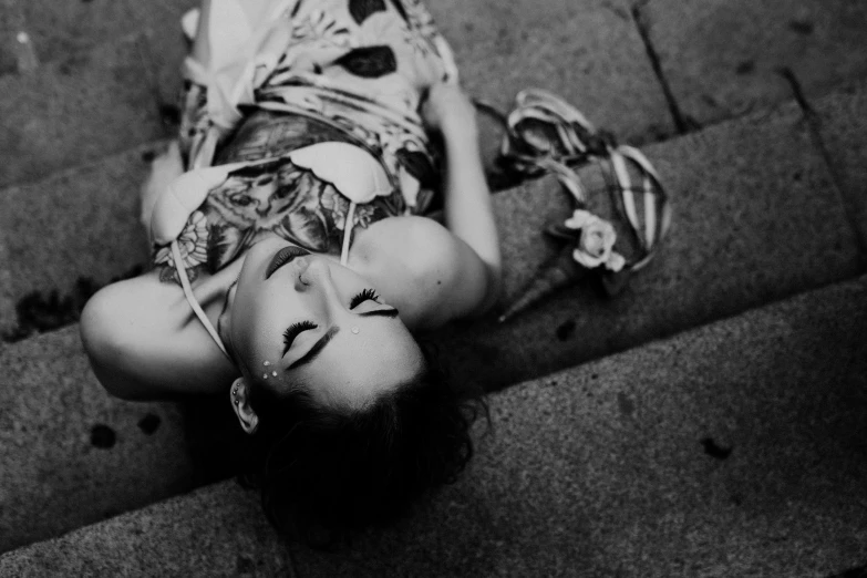 a young woman lays on the ground and stares straight into the camera