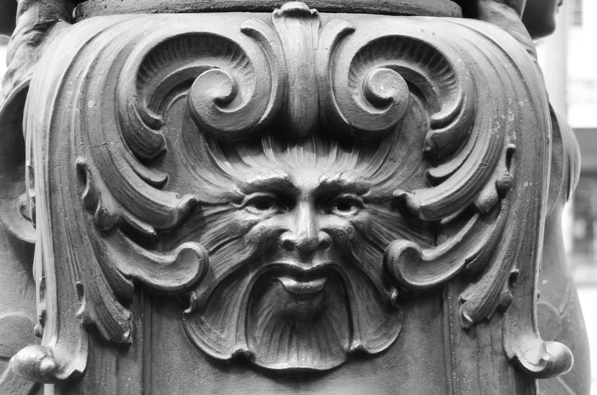 a black and white image of a face on a pillar