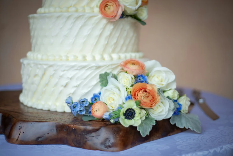 a wedding cake on a table with flowers on it