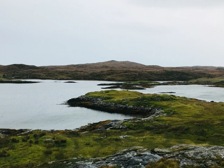 a body of water with land and grass around it