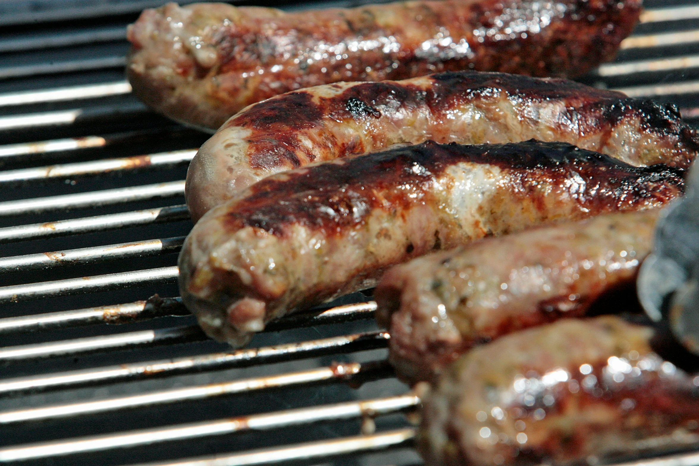 there are many cooked sausages that are on the grill