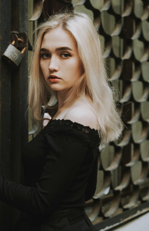 woman wearing black dress standing near large metal fence