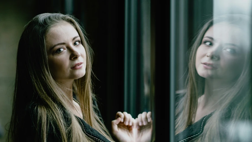 a beautiful young lady looking out a window