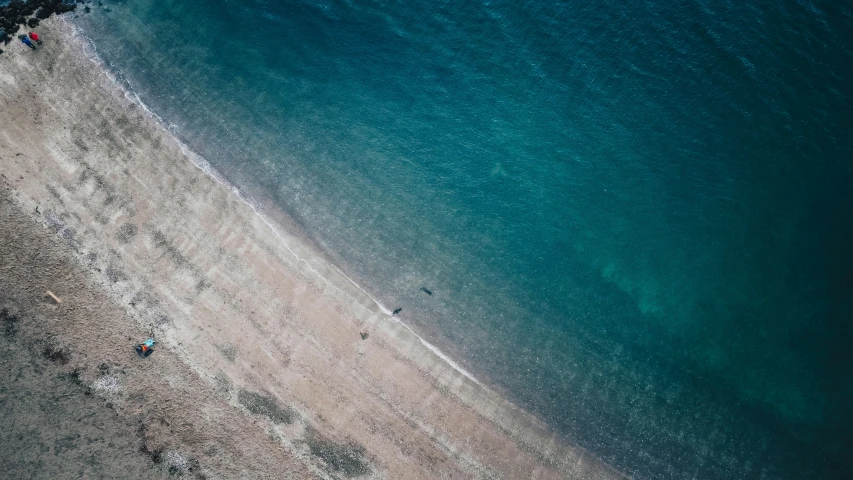 an aerial view of a sandy beach and a blue ocean