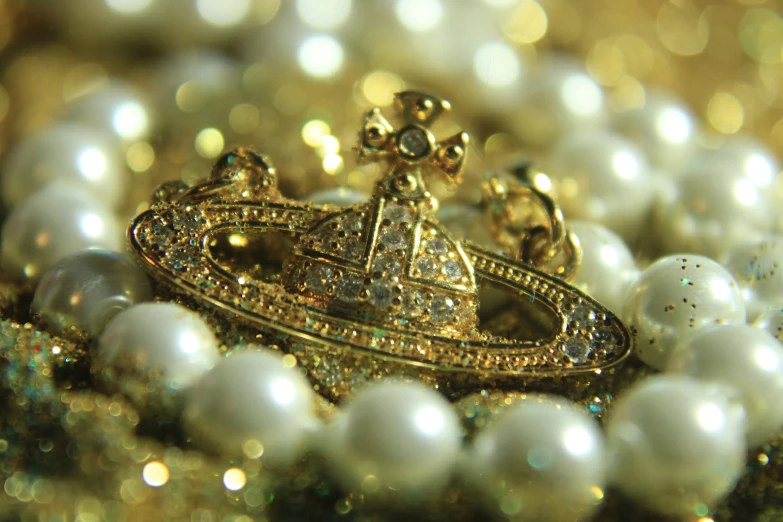 a white beaded necklace with gold charms and a crown