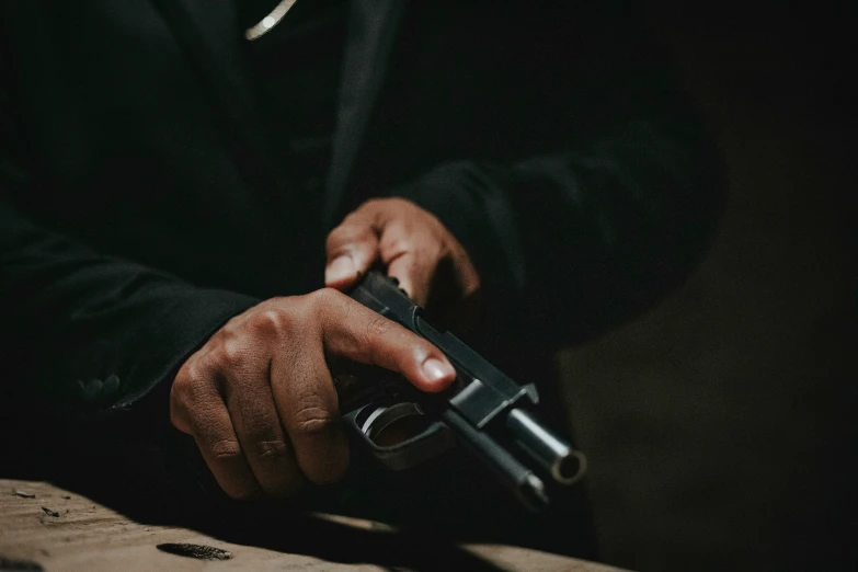 a man holding a black gun inside of his right hand