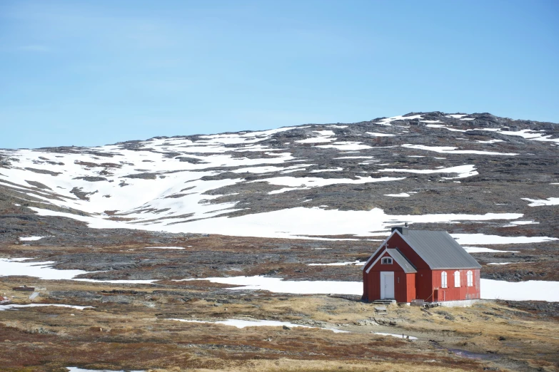 a small building stands on a mountain side