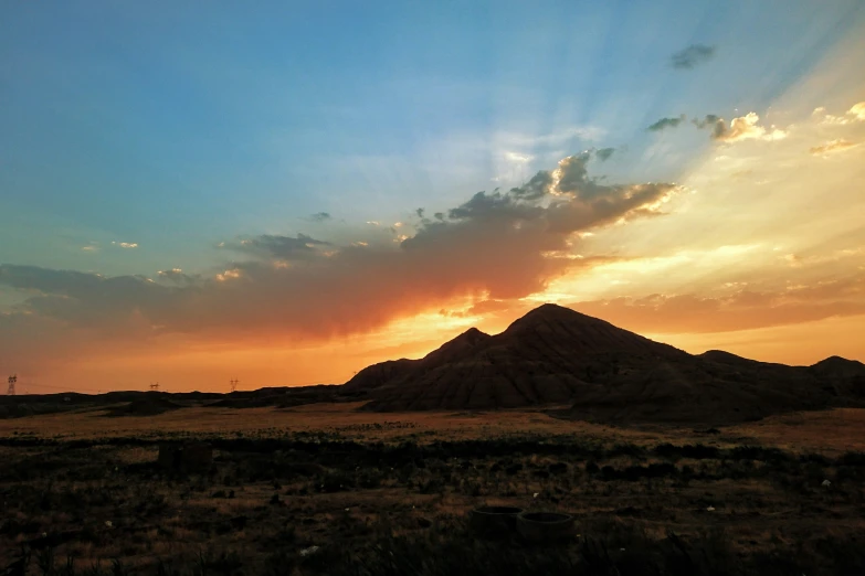 the sun rises behind a large mountain range