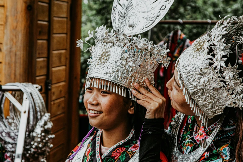 two women wearing elaborate clothing standing near each other