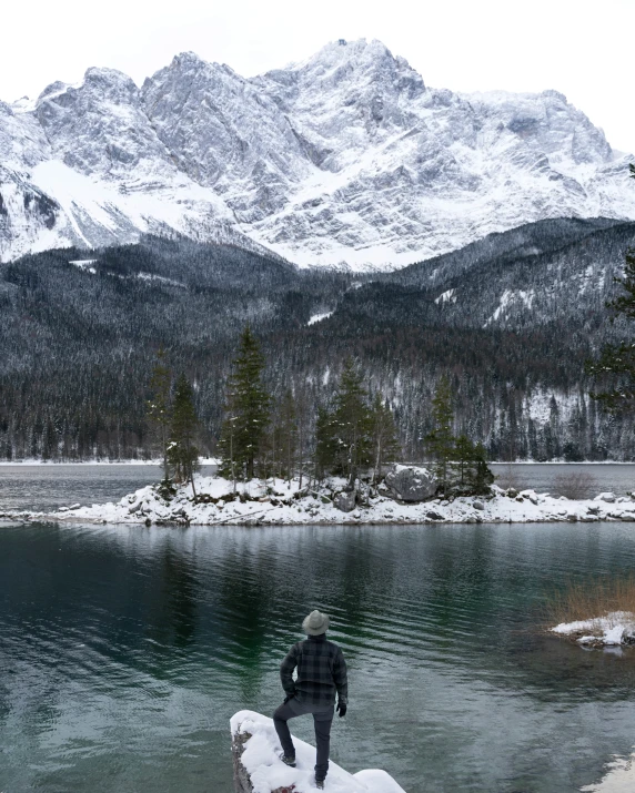 a person sitting on a rock looking at mountains in the background