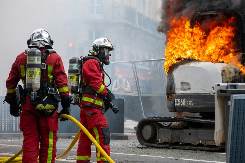 two fire fighters in red work on a fire