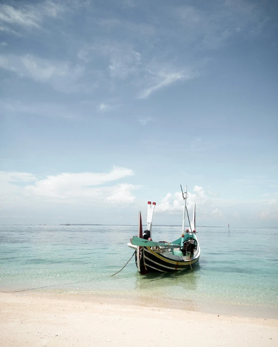 an old fishing boat anchored on the shore