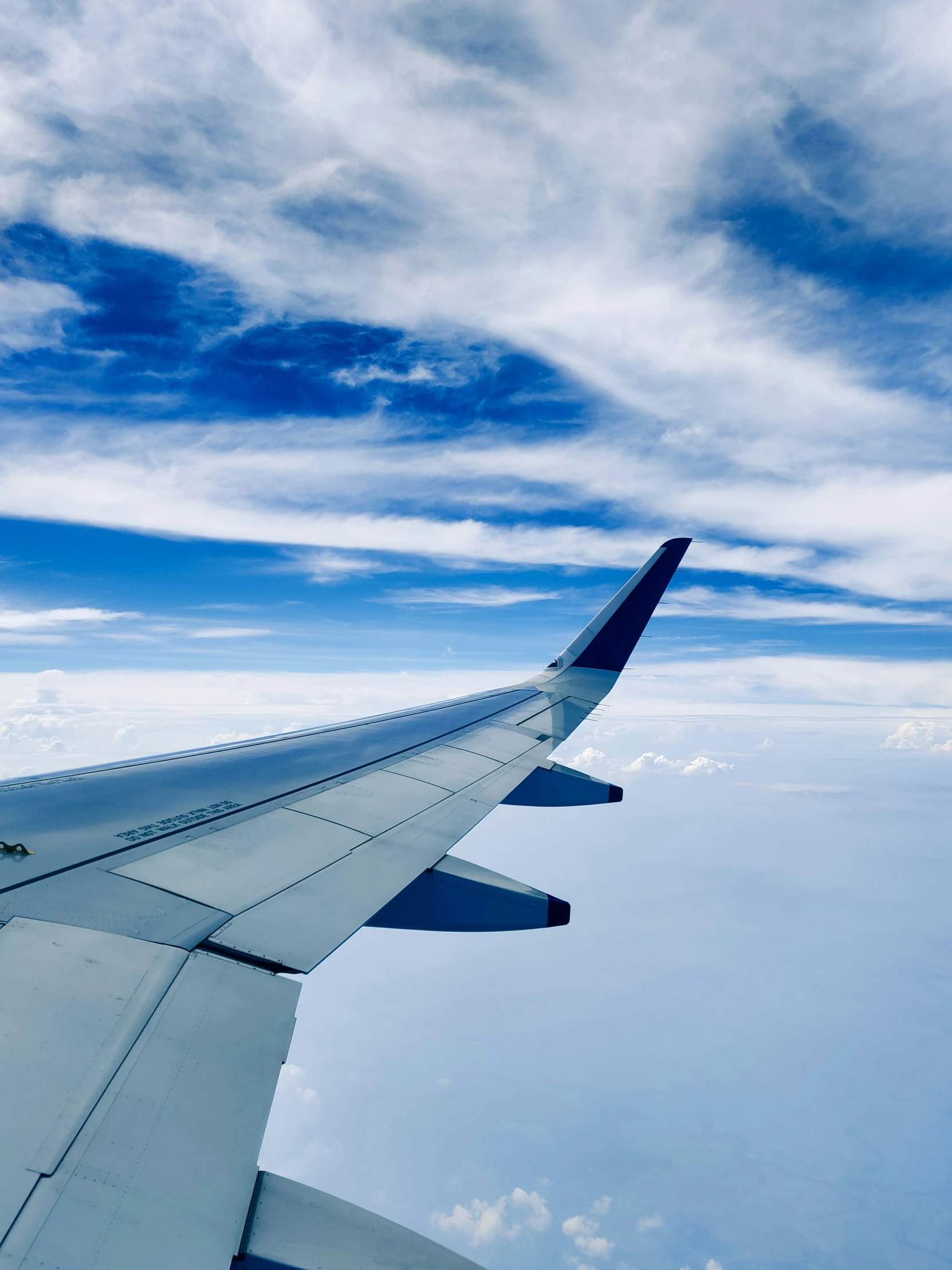 a view of the wing of an airplane over clouds