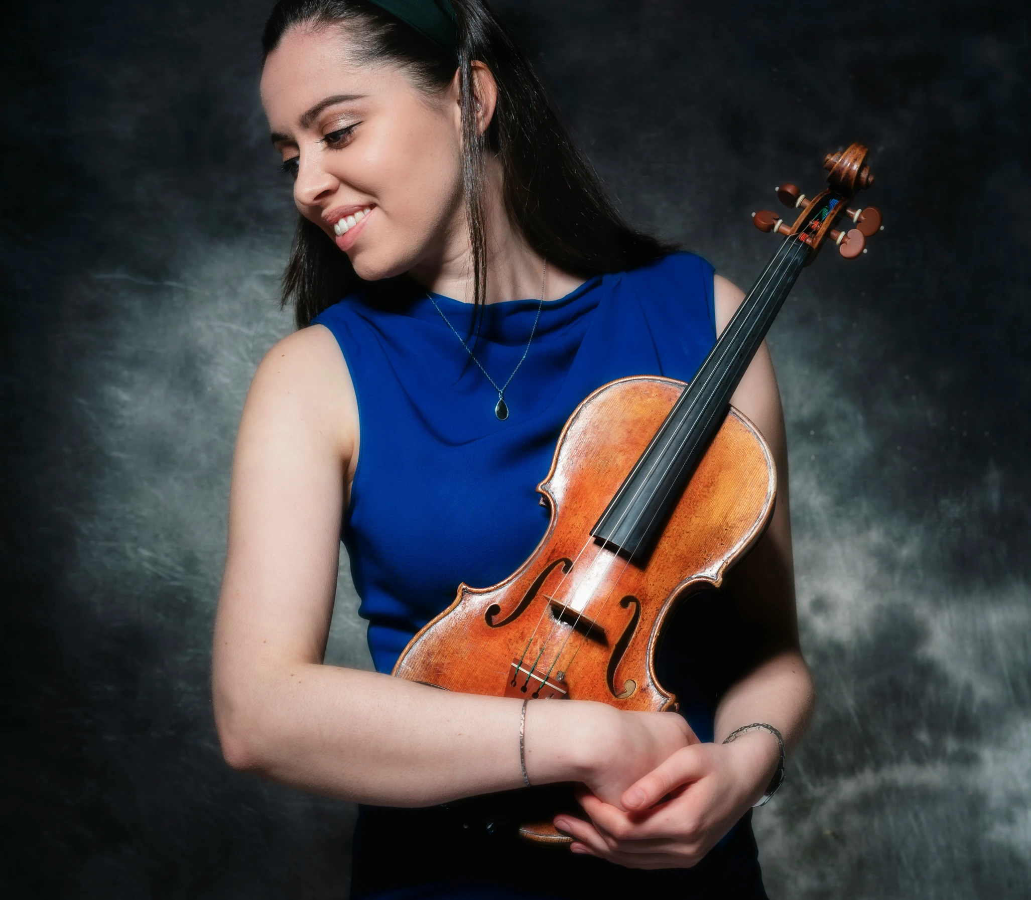 a smiling woman standing with her violin