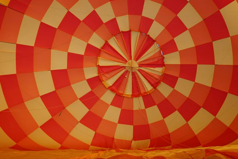 a red and yellow striped balloon with large holes in the center