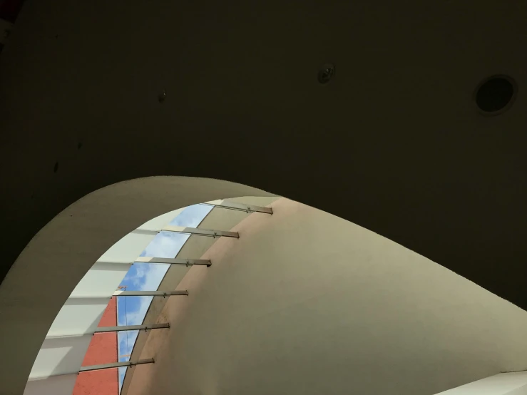 a curved wall and skylight in a museum