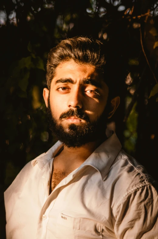 a bearded man with a beard standing against a wall