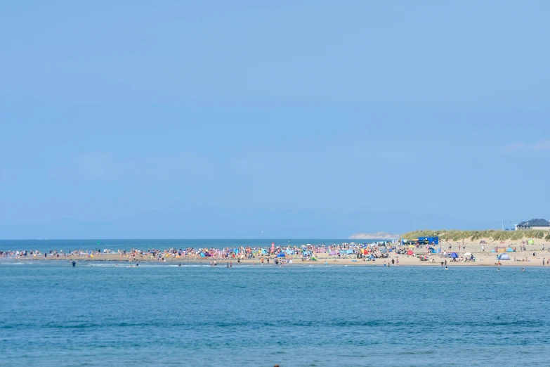 an ocean beach with a large crowd of people